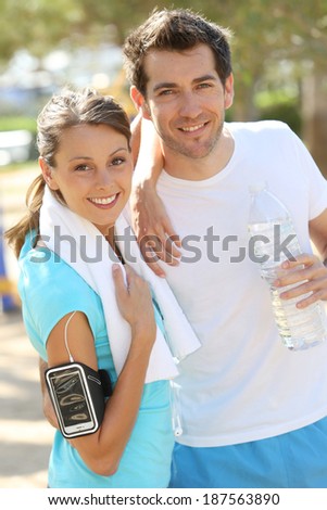 Cheerful couple of joggers looking at camera