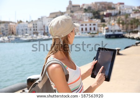 Cheerful tourist girl using digital tablet