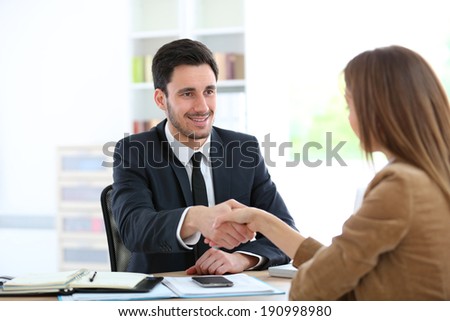Woman giving handshake to financial adviser