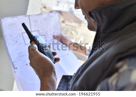 Entrepreneur on building site using walkie talkie