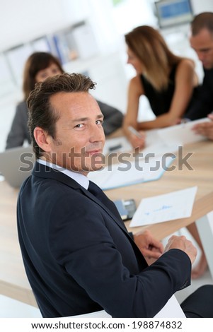 Portrait of corporate man sitting at meeting table