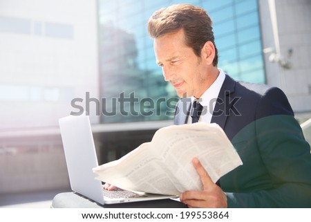 Businessman working on laptop computer outside the office