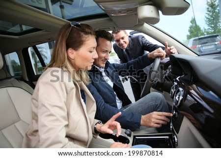 Car dealer showing vehicle binnacle to clients