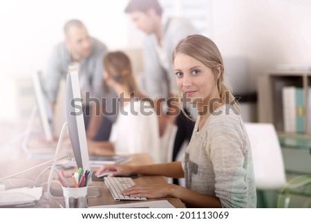 Young girl in office working on desktop computer