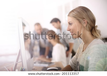 Young girl in office working on desktop computer