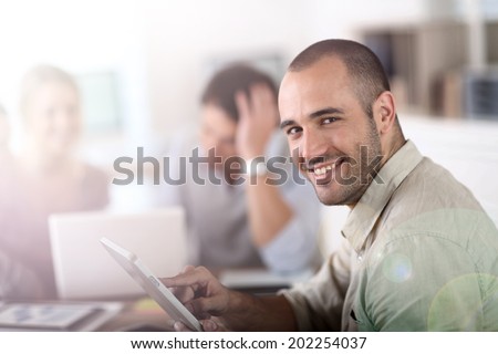 Young man in office working on digital tablet