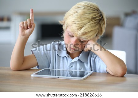 Little boy with tablet raising hand