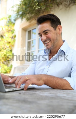 Mature man on week-end working from home with laptop
