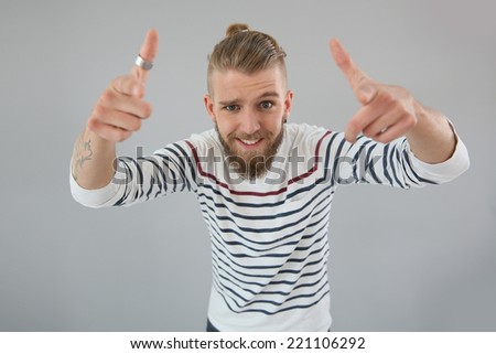 Portrait of trendy guy pointing hands towards calmra