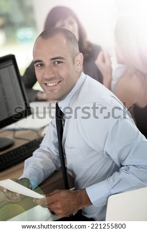 Young smiling businessman working on desktop computer