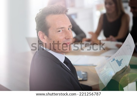 Portrait of corporate man sitting at meeting table