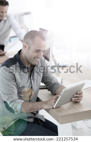 Young smiling man in training class using digital tablet