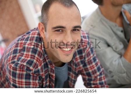 Smiling guy in shared apartment with roommates