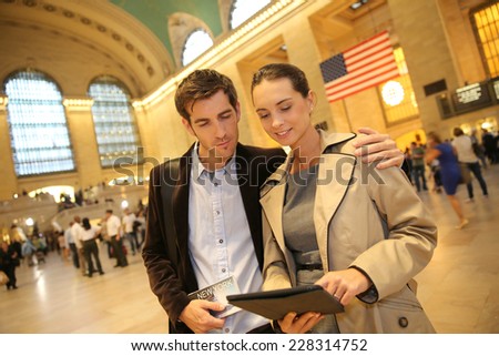 Couple in Grand Central station looking at train departure time