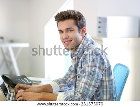 Young man in office working on laptop computer