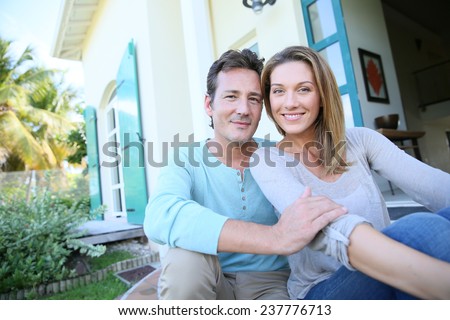 Middle-aged couple sitting on house front door