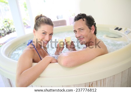 Romantic couple drinking cahmpagne in hot tub
