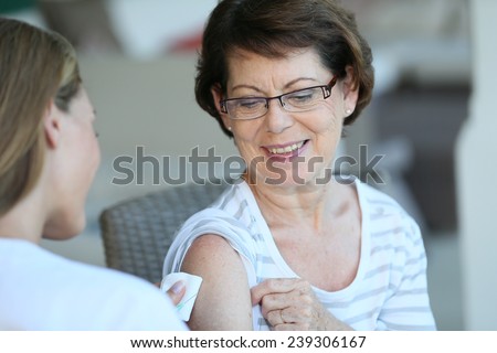 Senior woman receiving flu vaccine