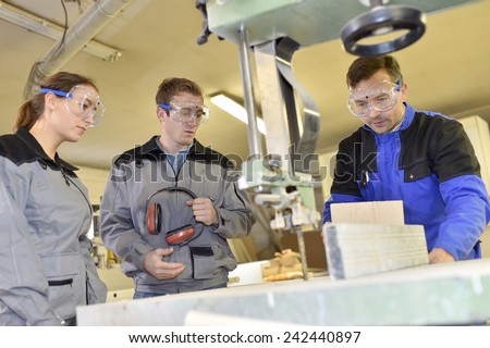 Group of students learning how to use woodwork machine