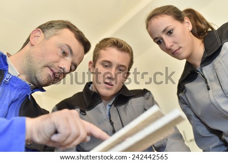Teacher with students using ceramic saw