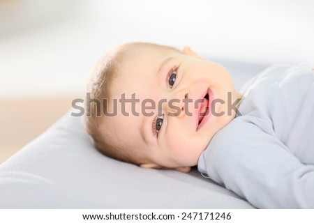 Portrait of smiling baby boy laying on changing table