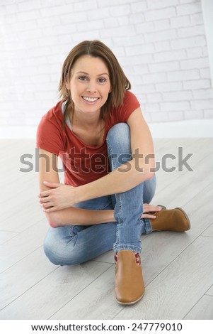 Portrait of young trendy woman sitting on floor