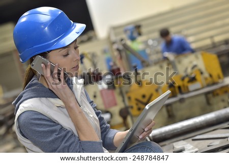 Woman in factory talking on mobile phone
