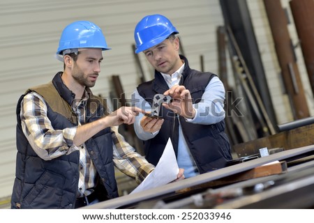 Engineer with mechanical worker checking on production