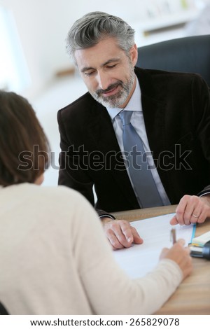 Attorney meeting client in office for signature