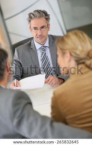 Mature couple signing contract in lawyer\'s office