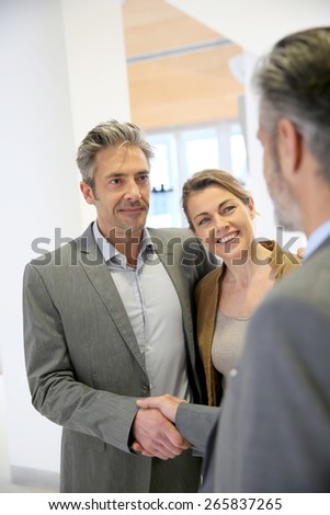 Adviser giving handshake to clients