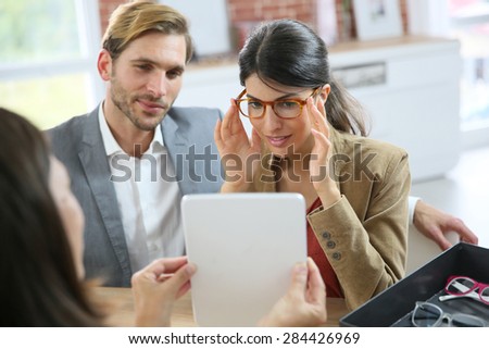 Couple in optical store trying eyeglasses on