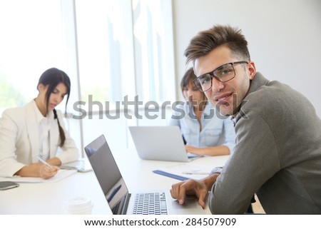 Portrait of businessman with eyeglasses sharing meeting room