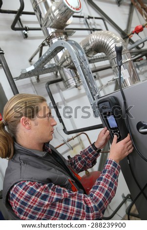 Technician checking heat pump intensity with electronic device