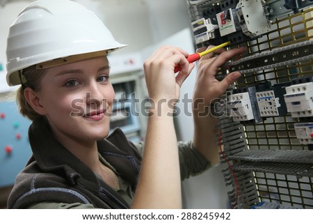 Young woman in professional training setting up electrical circuit