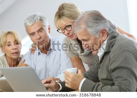 Group of retired senior people using laptop and tablet