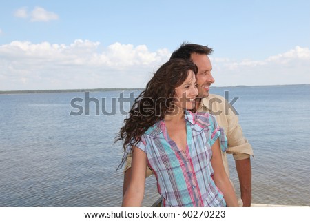 Closeup of loving couple standing on a pontoon by a lake