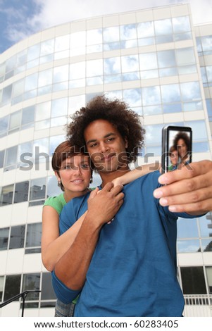 Young couple taking picture of itself with mobile phone