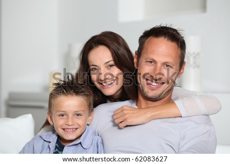 Closeup of parents and child relaxing at home on sofa