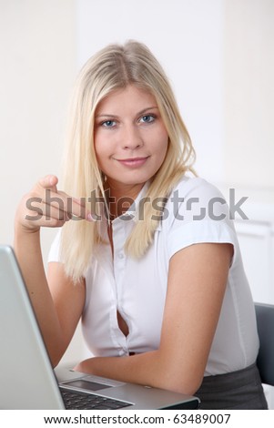Blond businesswoman doing funny faces in the office