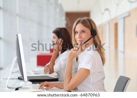 Business people working in front of computer with headphones
