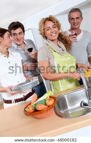 Group of friends preparing dinner in home kitchen