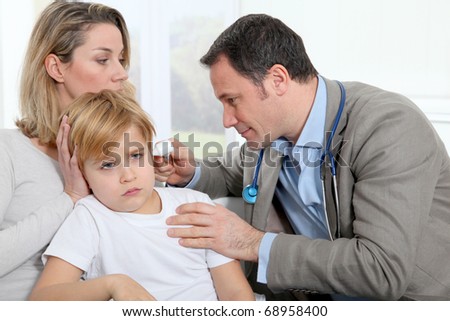 Doctor checking little boy\'s ear infection