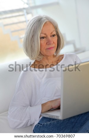 Senior woman surfing on internet at home