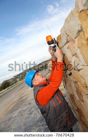 Worker with security helmet installing gate system