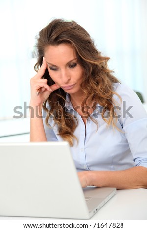 Office worker with desperate look in front of laptop