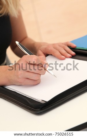 Closeup of woman signing contract