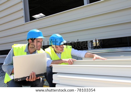 Construction workers checking building material