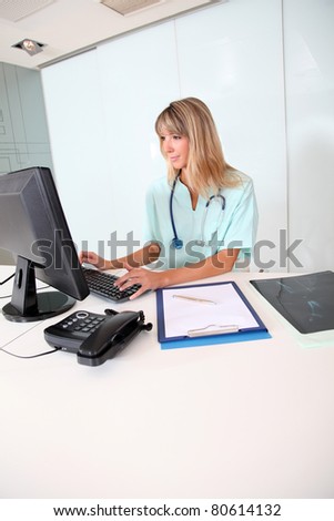 Nurse working on desktop computer in office