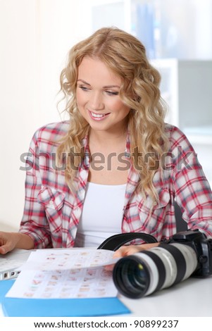 Beautiful photographer looking at story board for photo session